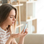 Diabetic woman checking blood sugar level at home