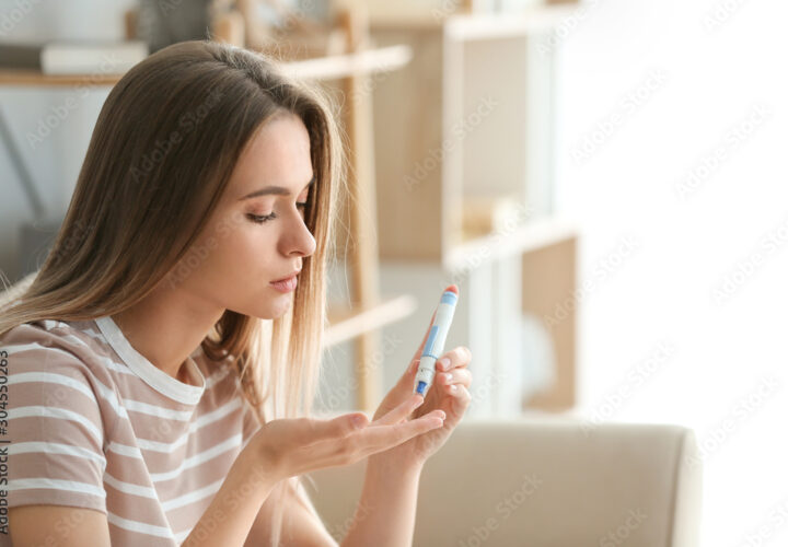 Diabetic woman checking blood sugar level at home